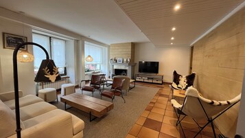 A modern living room with a fireplace, a television, and a cozy seating area.