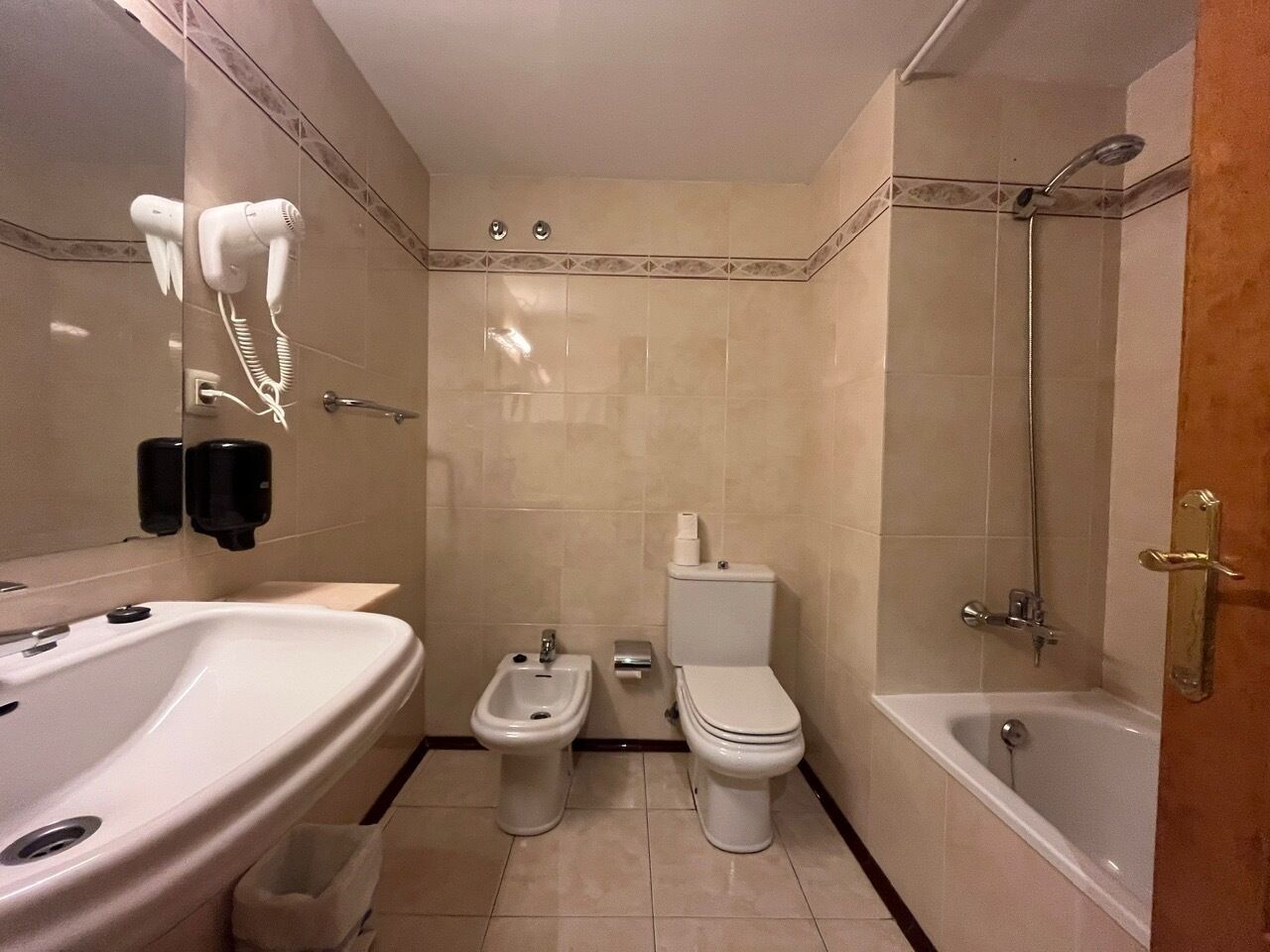 Un baño con lavamanos, bidé, inodoro y bañera.