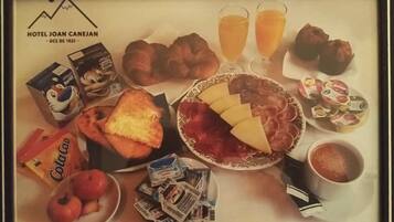 Een ontbijfwagen met croissants, kaas, ham, toast, sap en koffie.