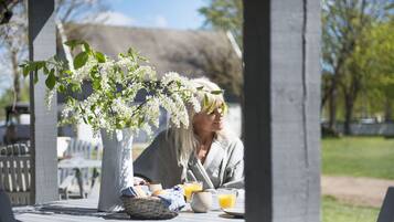 Ett bord med en vas med blommor, en korg och en tallrik med en dryck.