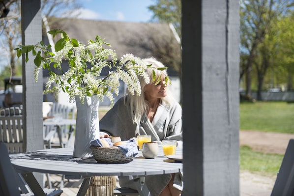 A table with a vase of flowers, a basket, and a plate with a drink.