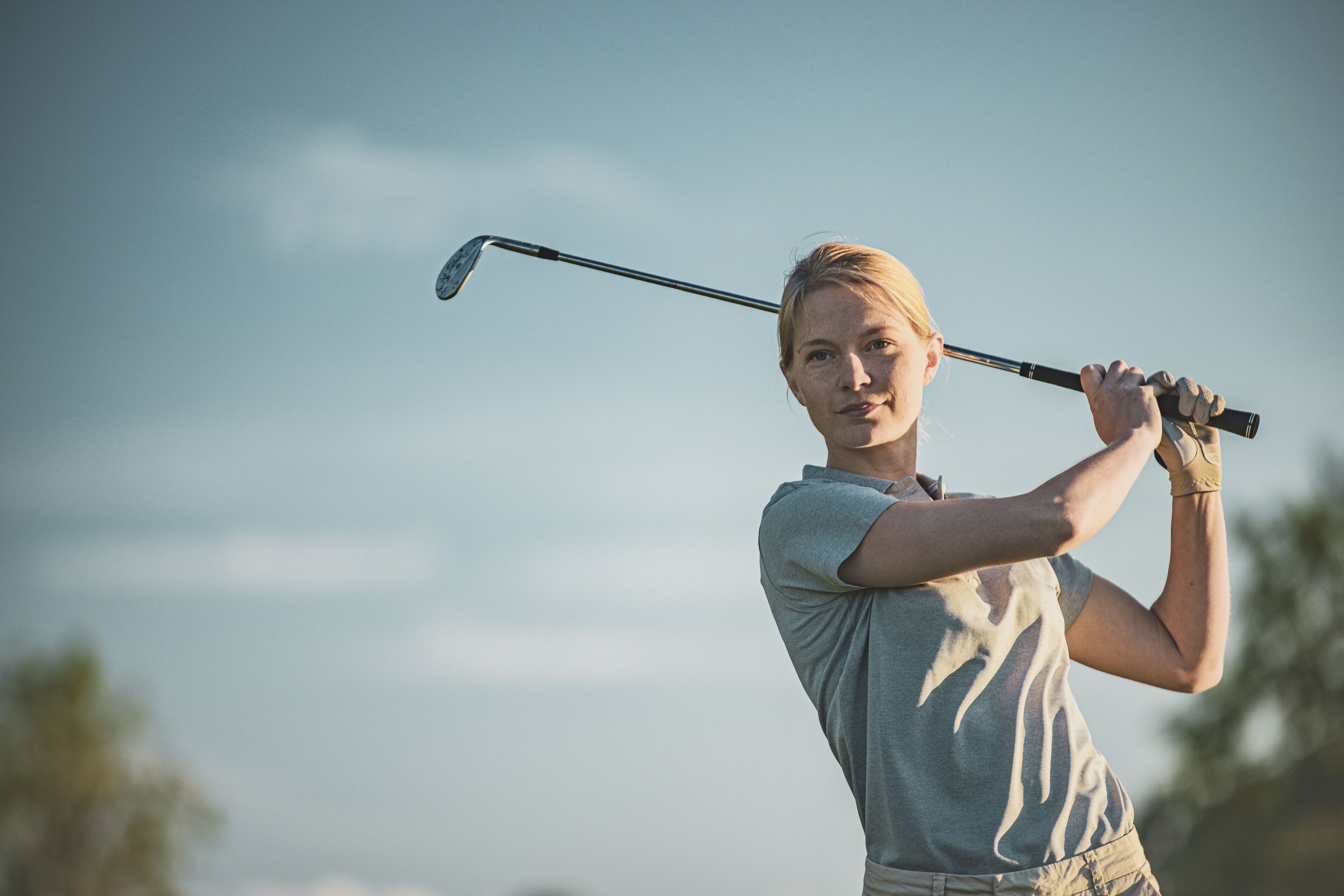 A person holding a golf club, ready to swing.