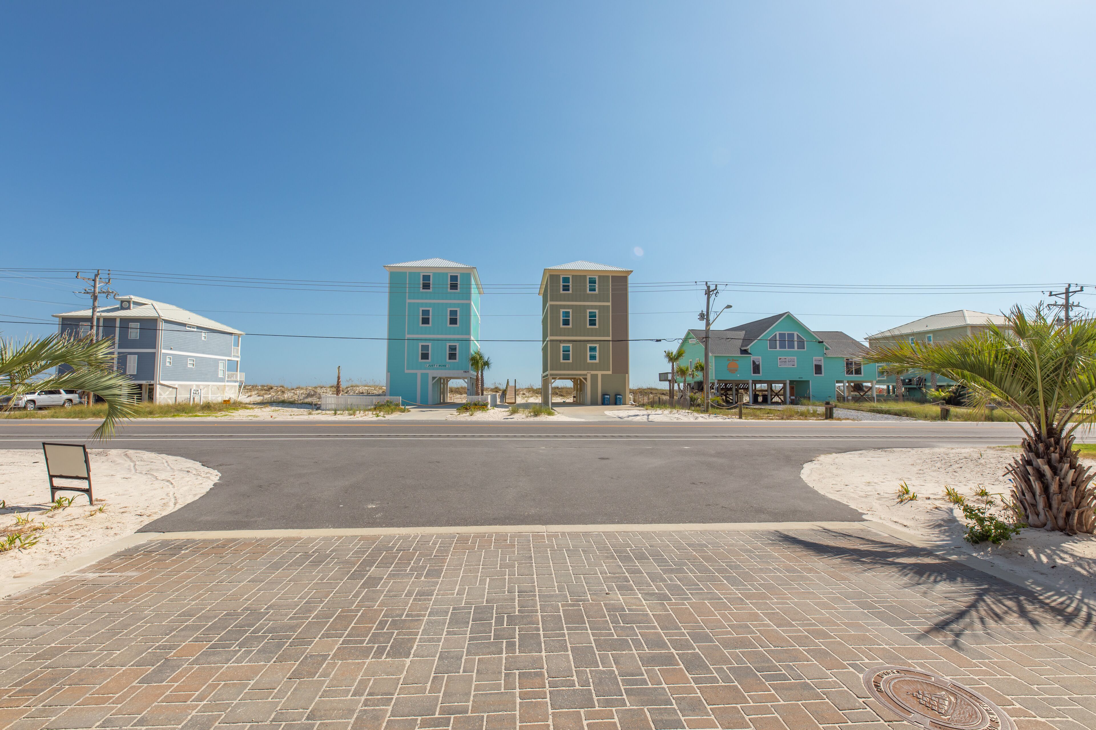 A paved area with a road leading to a row of buildings.