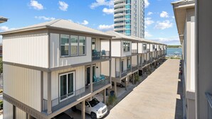 A multi-story residential building with balconies and a view of the sea. - Little Lagoon Cottages (Gulf Shores)