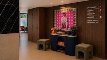 Un hall d’entrée moderne avec un mur en bois, un espace salon et un comptoir d’accueil.