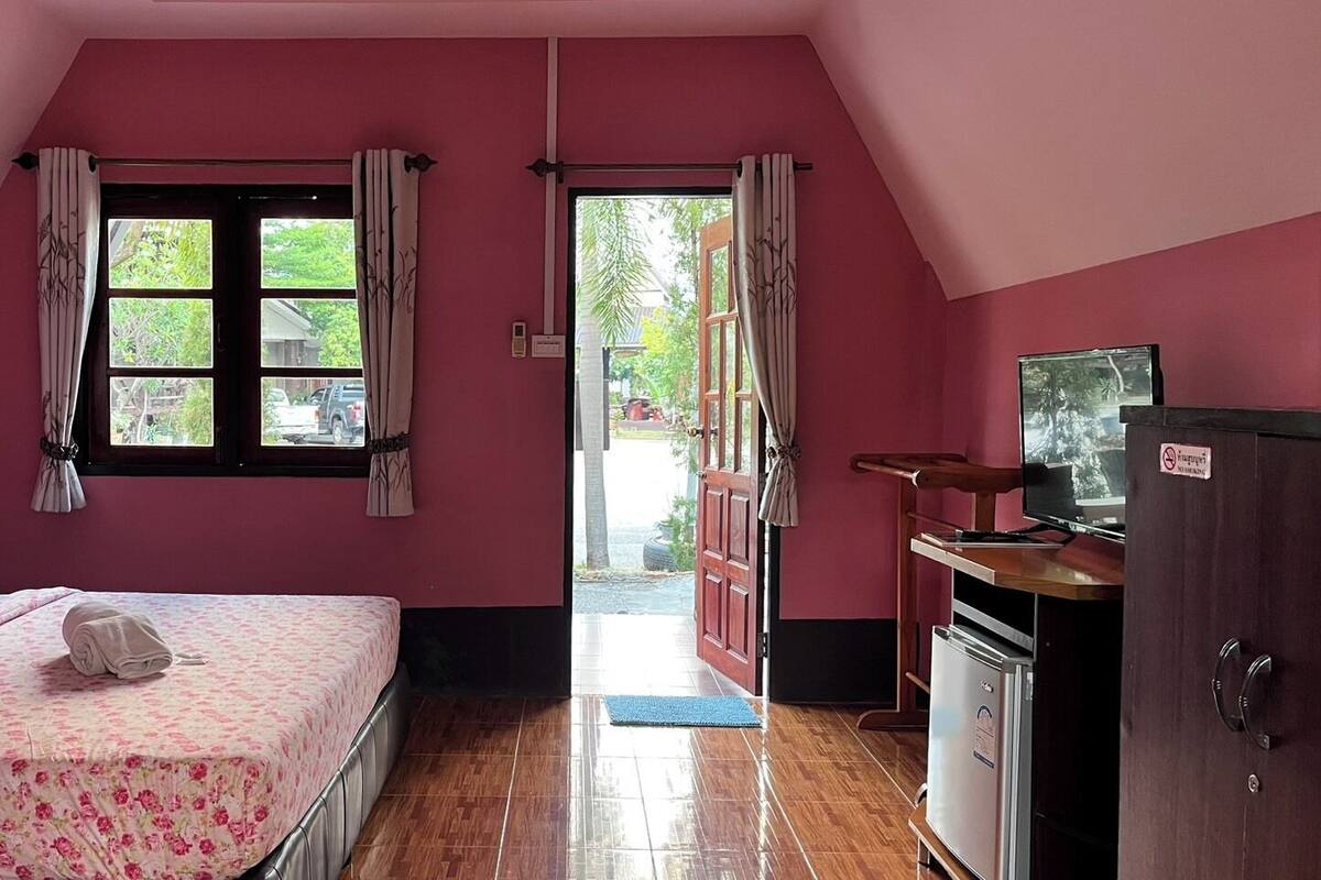 A room with a bed, a television, and a wardrobe.