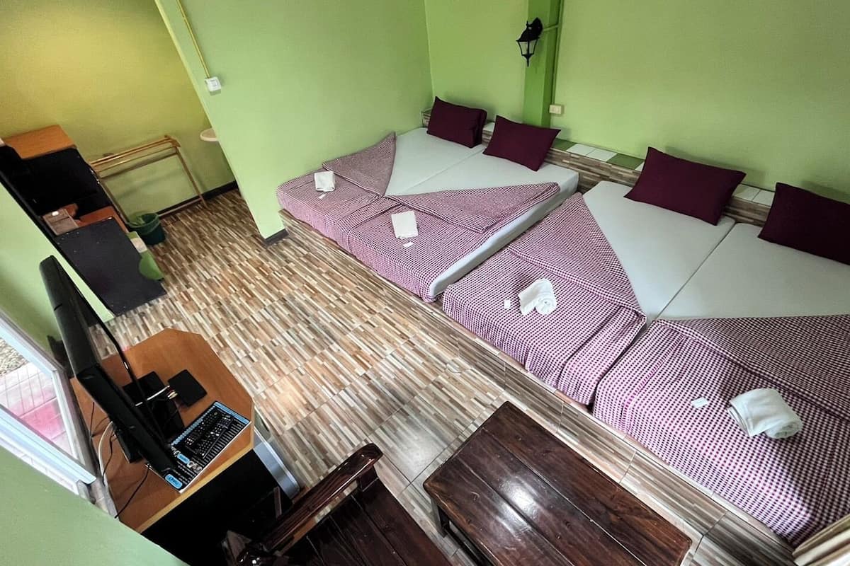 A room with two beds, a desk, and a chair.