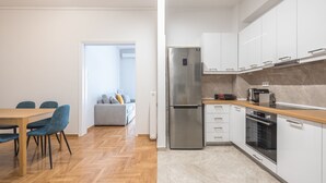 Una cucina moderna con pensili bianchi, un frigorifero in acciaio inossidabile e un piano di lavoro in legno.