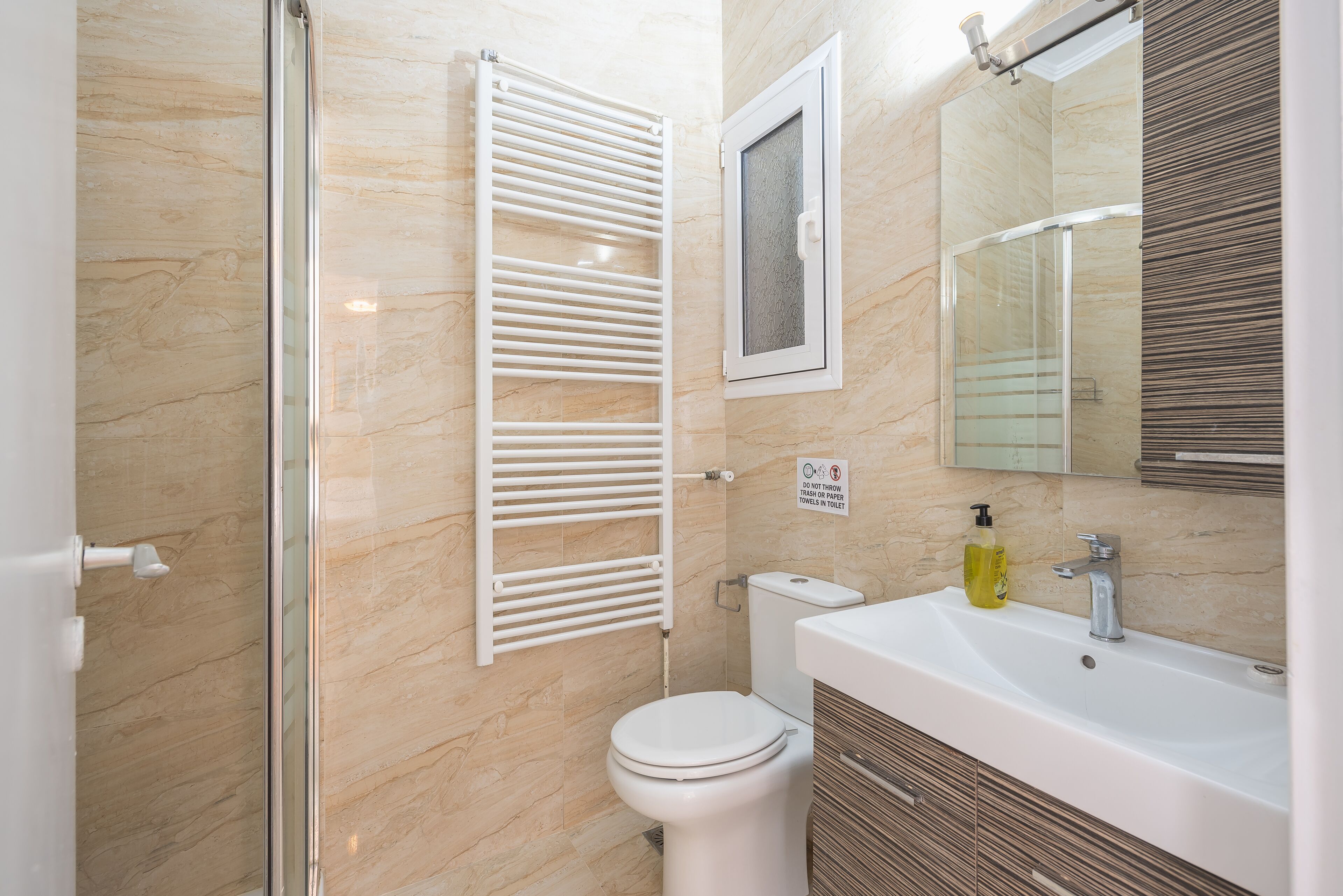 A bathroom with a shower, toilet, sink, and mirror.