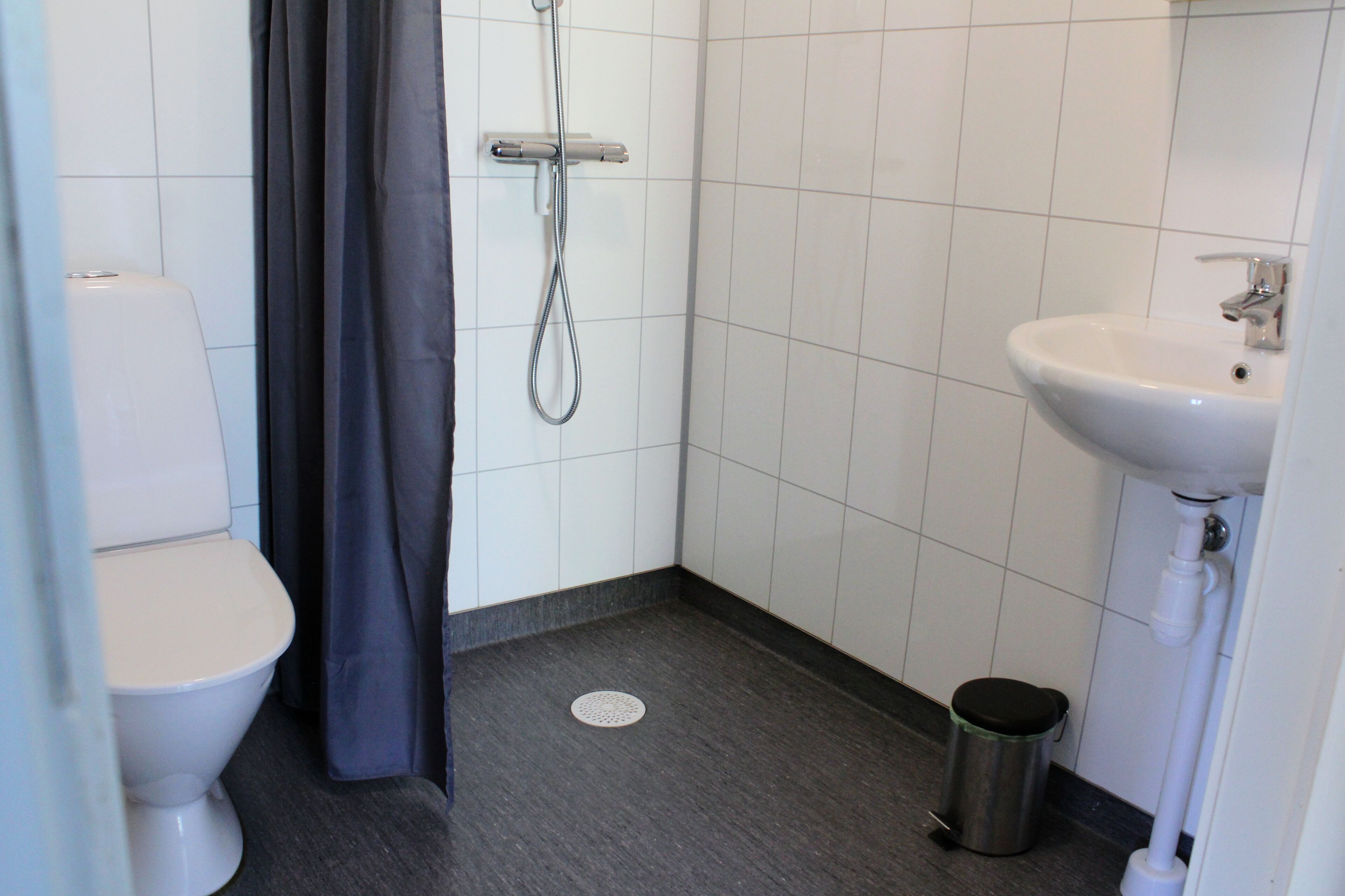 Un baño pequeño con inodoro, ducha y lavamanos.