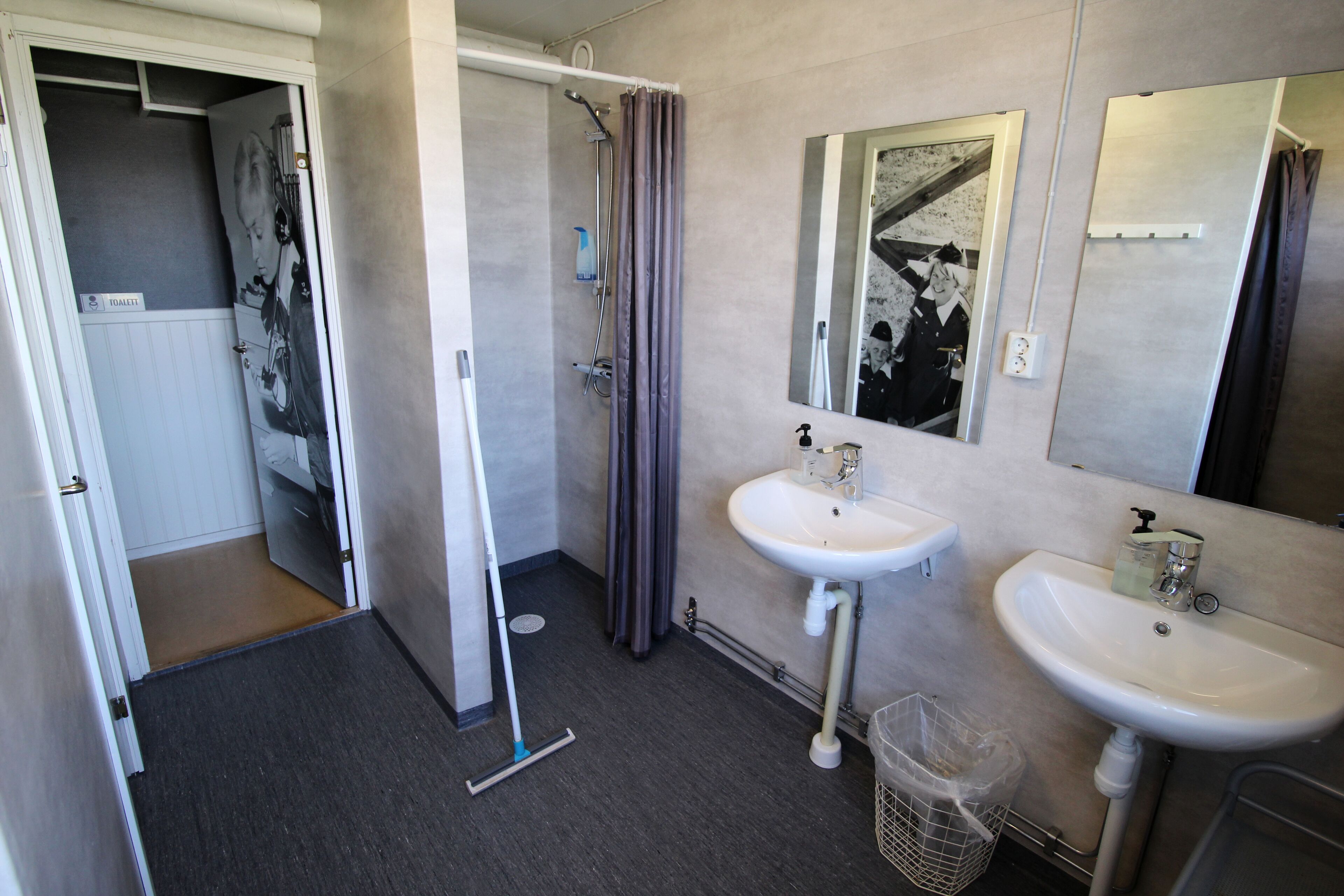 A bathroom with two sinks, a shower, and a mirror.