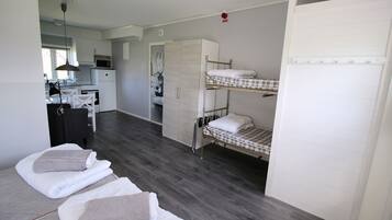 Et lille værelse med køjesenge, tekøkken og garderobe.