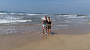 Two people standing on a sandy beach with waves in the background. - Villa Seven Panadura (Panadura)