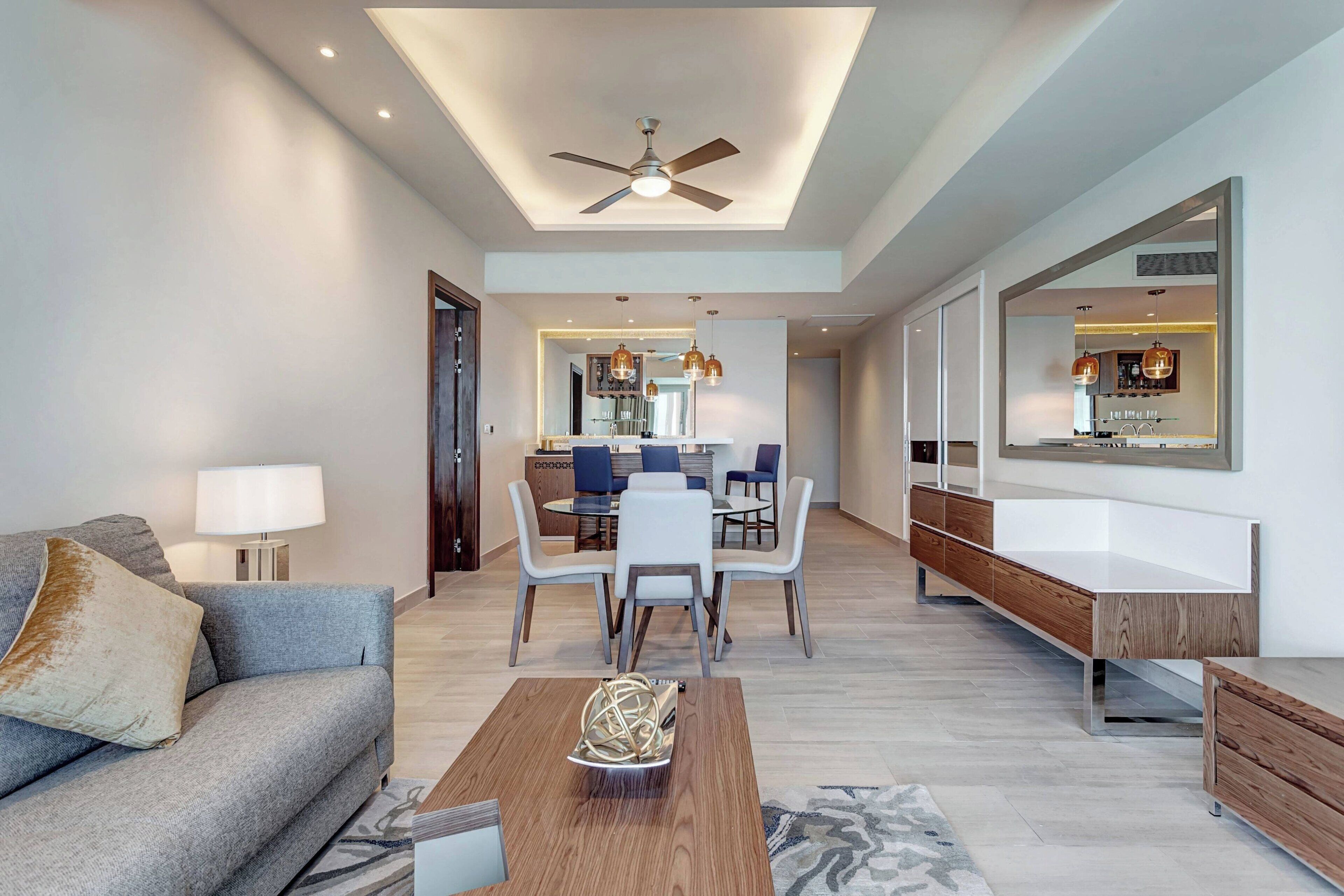Una sala de estar moderna con un sofá, una mesa de centro y un comedor con sillas y una mesa.