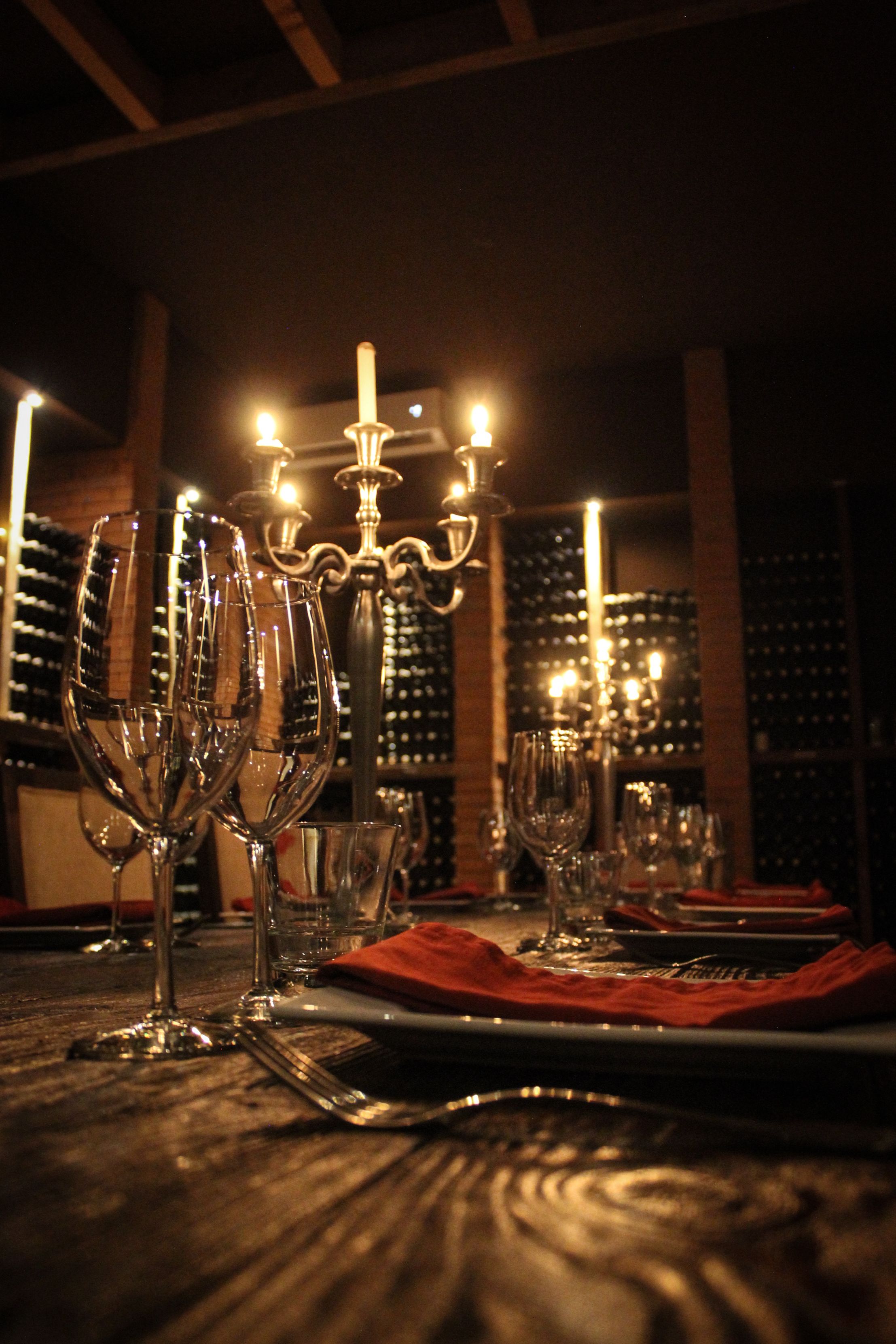Una mesa puesta con copas de vino y un candelabro.