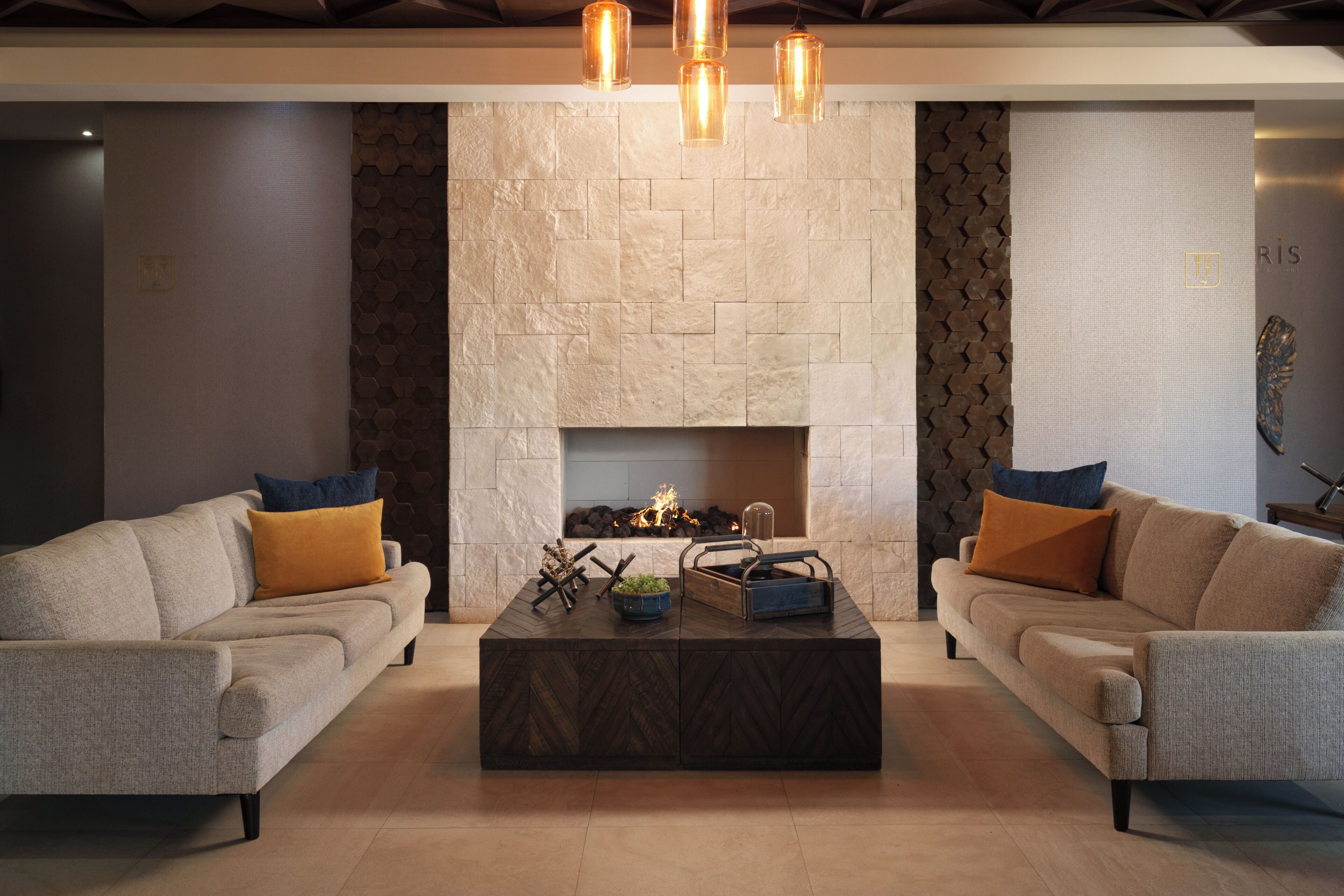A modern living room with two sofas, a fireplace, and a coffee table.