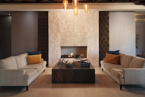 A modern living room with two sofas, a fireplace, and a coffee table.