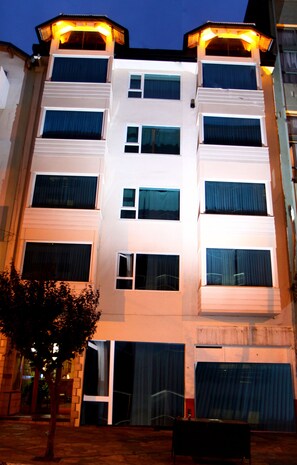 A multi-story building with balconies and large windows.