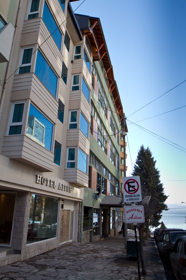 A hotel with a sign indicating no parking and a sign for a hostel.