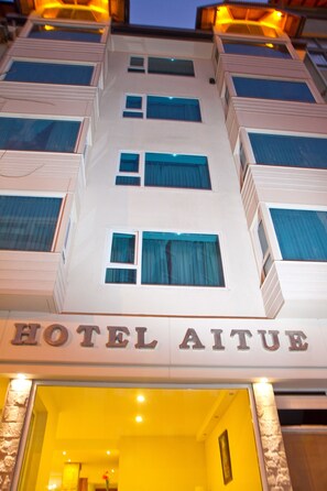 Ein mehrstöckiges Hotel mit einem Schild, auf dem "HOTEL AITUE" steht.