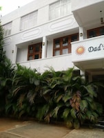 A building with a sign reading "Dad's" and a sun symbol, surrounded by lush green palm trees.