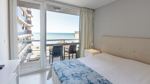 A bedroom with a large window, a bed, a desk, and a chair. - DeptosVip (Mar del Plata)