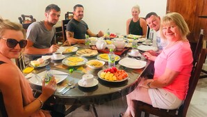A round dining table with various dishes, cups, and bottles. - Paraiso Guest House (Ella)