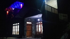 A building with a stone facade, large windows, and a wooden door. - Paraiso Guest House (Ella)