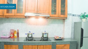 Una cocina con armarios de madera, estufa a gas y refrigerador.