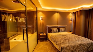A hotel room with a large bed, a glass-enclosed shower, and a visible sign reading "ROLLI BUTIK HOTEL". -  Rolli Butik Hotel (Anamur)
