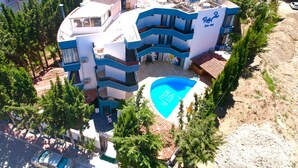 A multi-story hotel with a swimming pool and outdoor seating areas. -  Rolli Butik Hotel (Anamur)