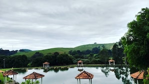 A tranquil lakeside setting with gazebo-style shelters and a clear view of the surrounding hills. - Pousada e Pesca Esportiva Fazolin (Socorro)