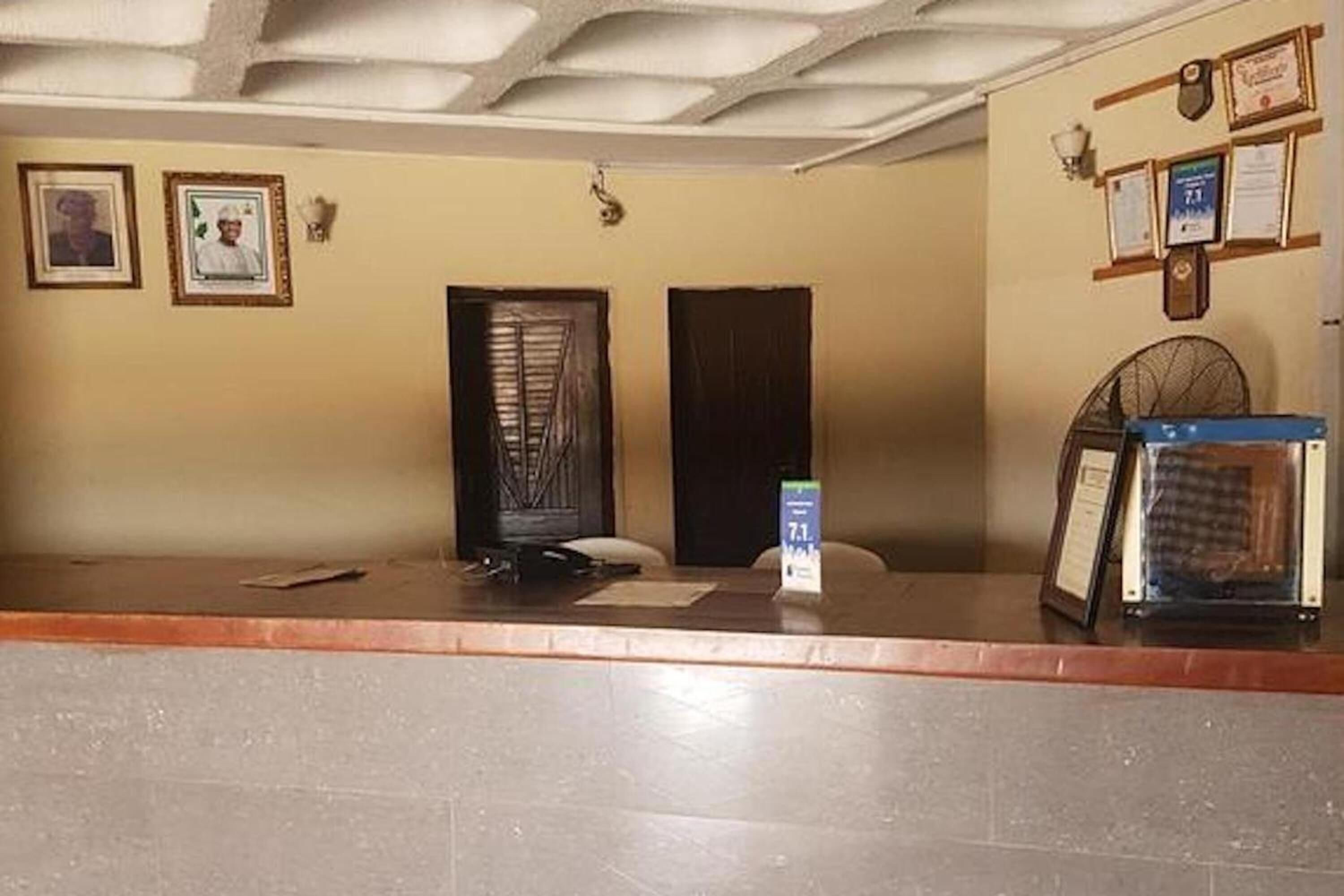 A reception area with a counter, framed certificates on the wall, and a door with a window.