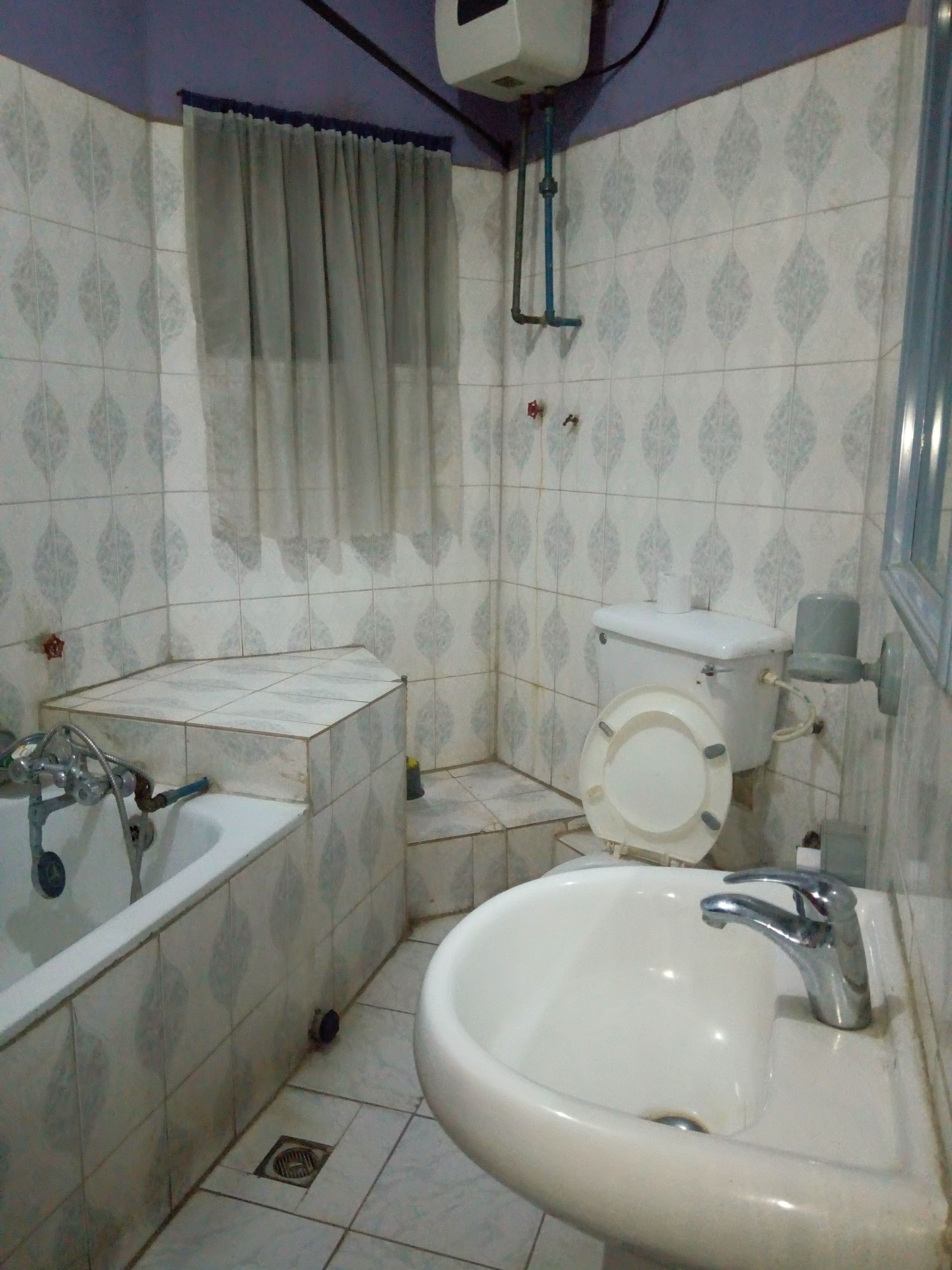Een compacte badkamer met een wastafel, toilet en bad.