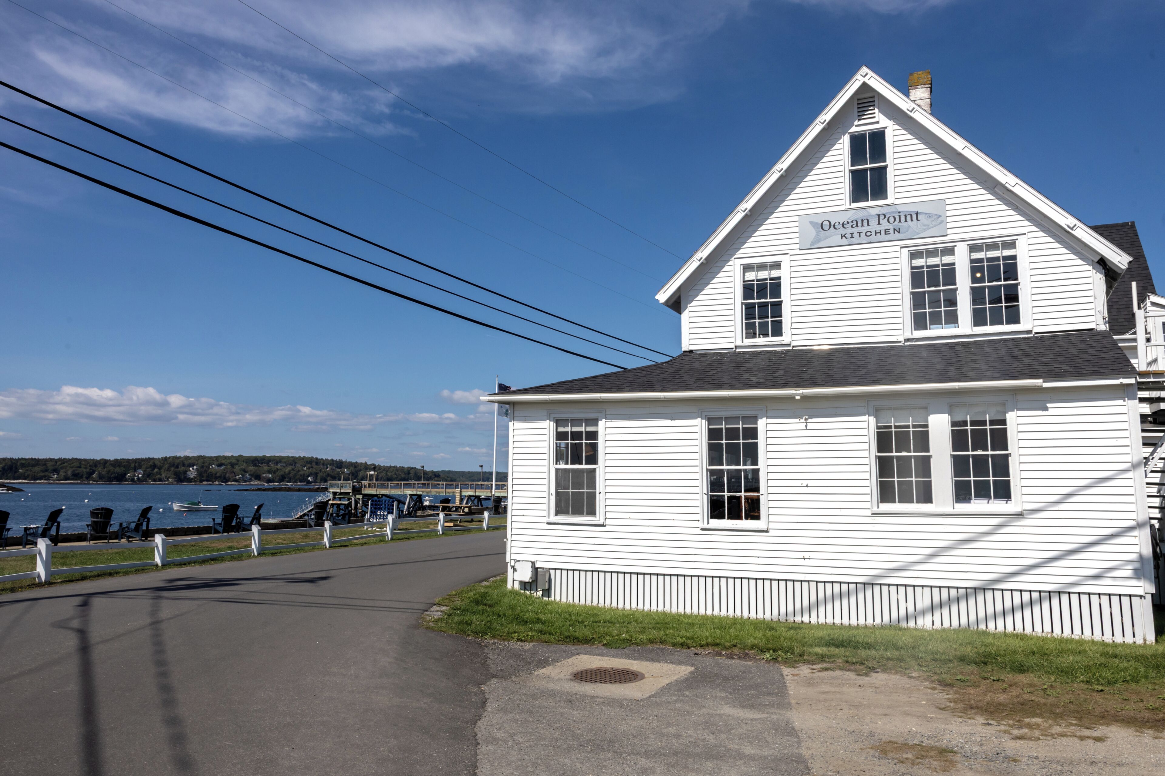 A white two-story building with a sign reading 'Ocean Point Kitchen.'