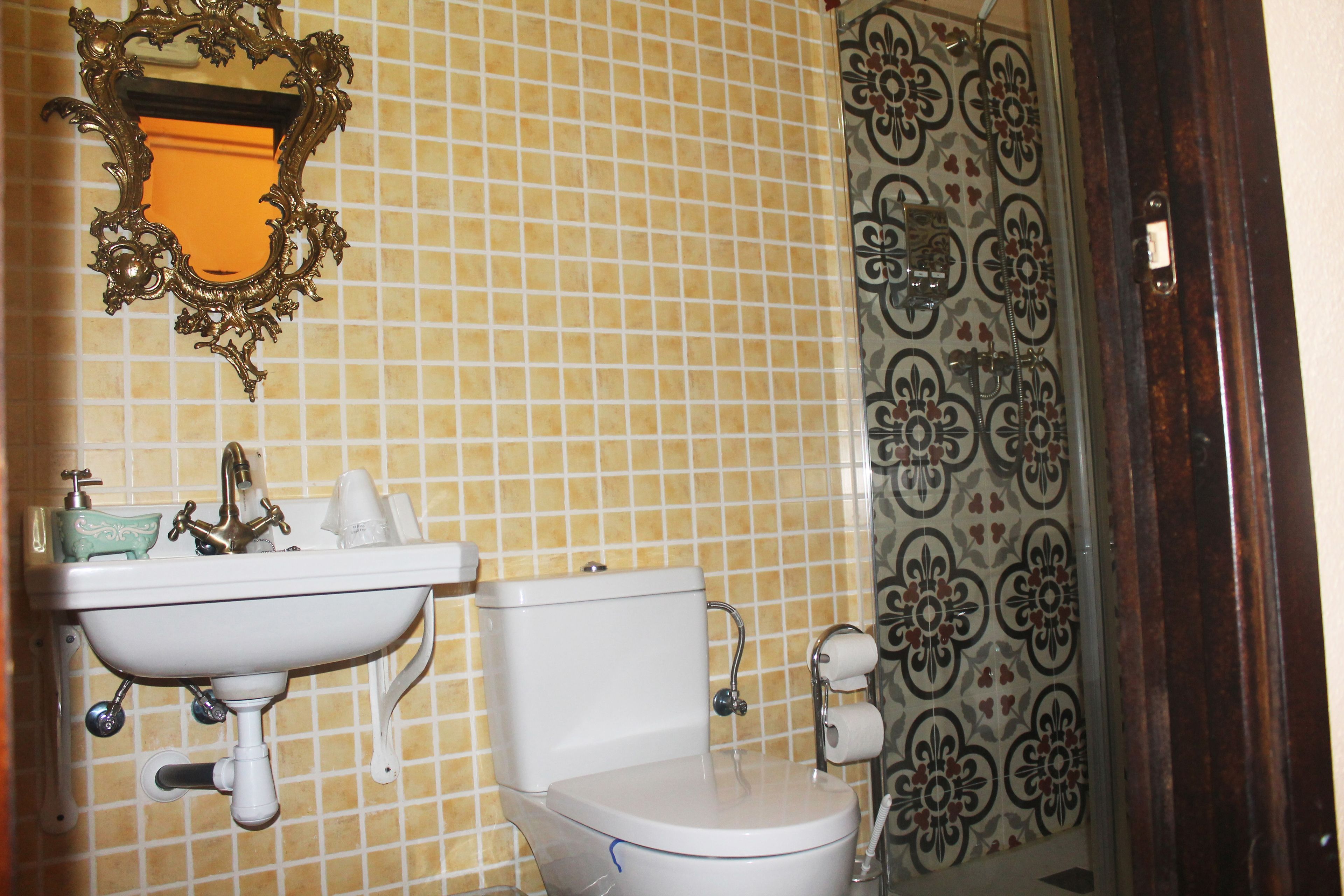 Een badkamer met een wit wastafel, toilet en spiegel.