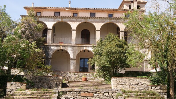A building with multiple arches and a balcony. - Hostal Rural Mas Blanc (Sant Marti de Centelles)