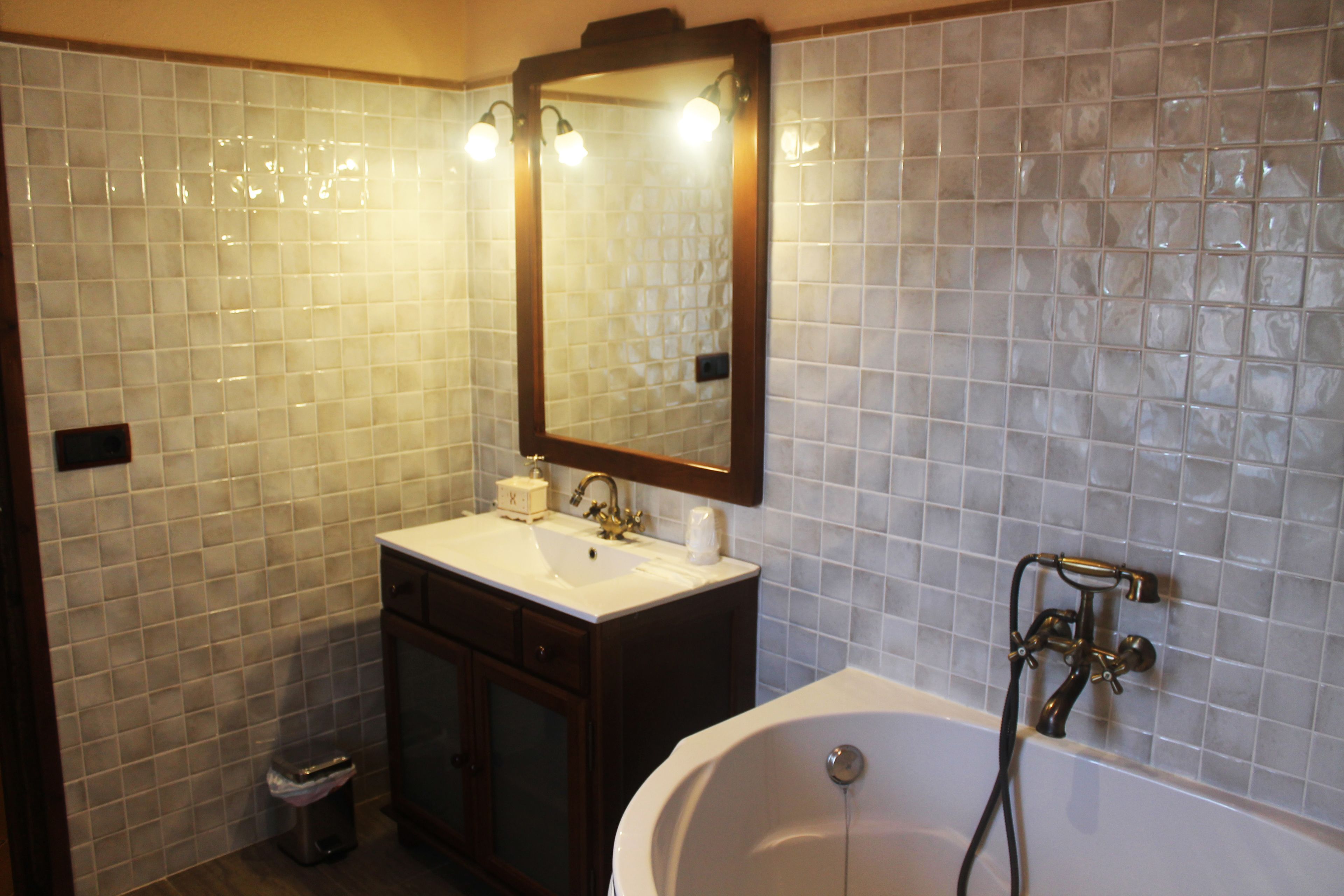 A bathroom with a white sink, mirror, and bathtub.