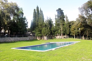 Una piscina al aire libre, tumbonas