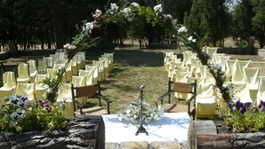 An outdoor wedding venue with rows of yellow chairs and a wooden bench. - Hostal Rural Mas Blanc (Sant Marti de Centelles)