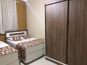 A hotel room with two beds, a large wardrobe, and a curtain. - APARTAMENTO EM COPACABANA (Rio de Janeiro)