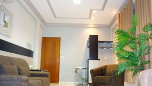 A living room with two sofas, a coffee table, a lamp, and a potted plant. - Carajas Hotel (Parauapebas)