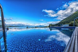 An infinity pool with a clear view of a mountain range and a lake. - Luxurious Villa Kastro (Lefkada)
