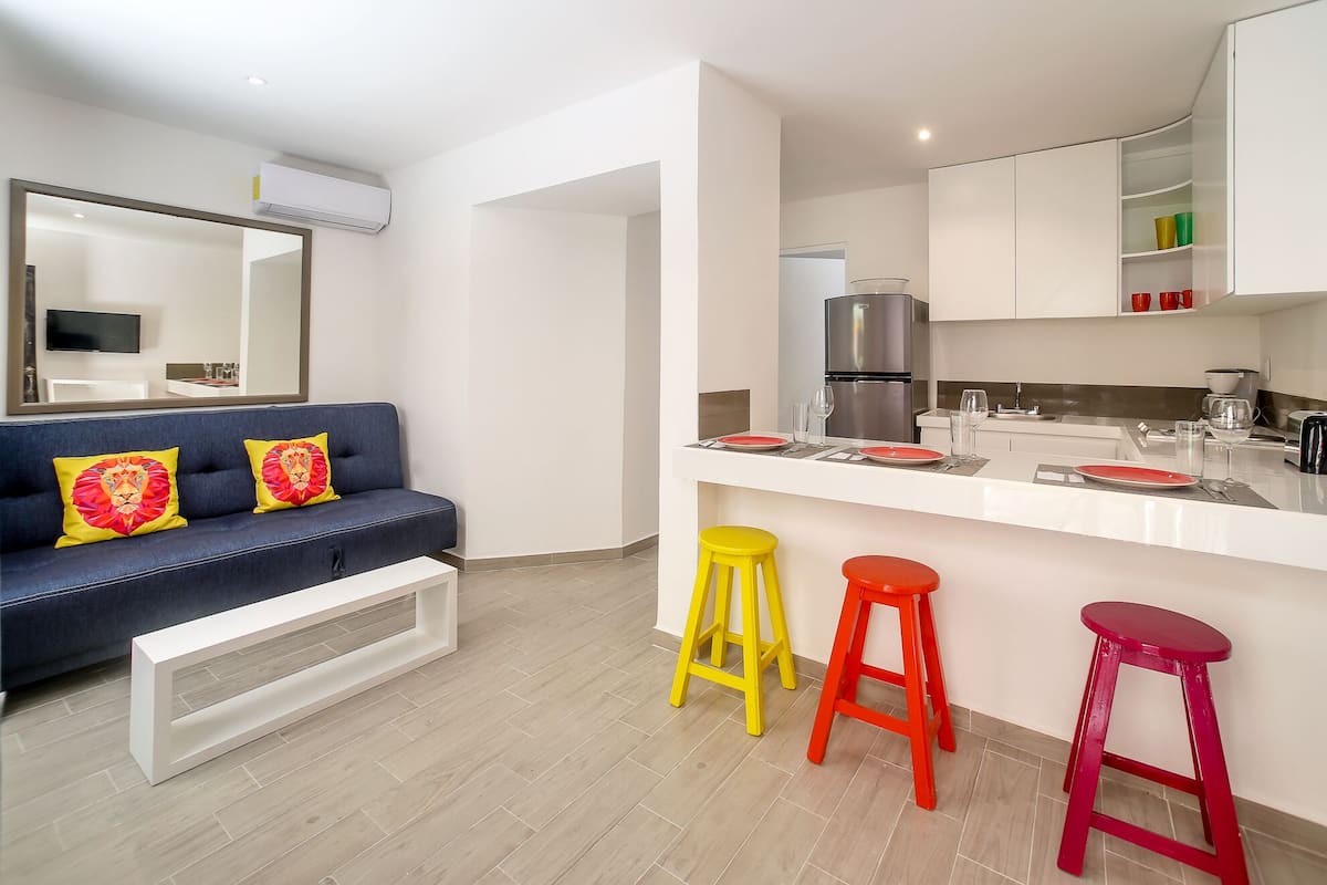 A modern apartment with a living area, kitchen, and dining space.