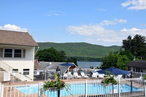 Una piscina al aire libre, sillones reclinables de piscina