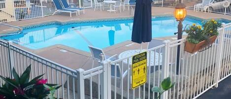 Una piscina al aire libre, tumbonas