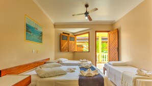 Habitación de hotel con dos camas, ventilador de techo, un cuadro y vistas al exterior.
