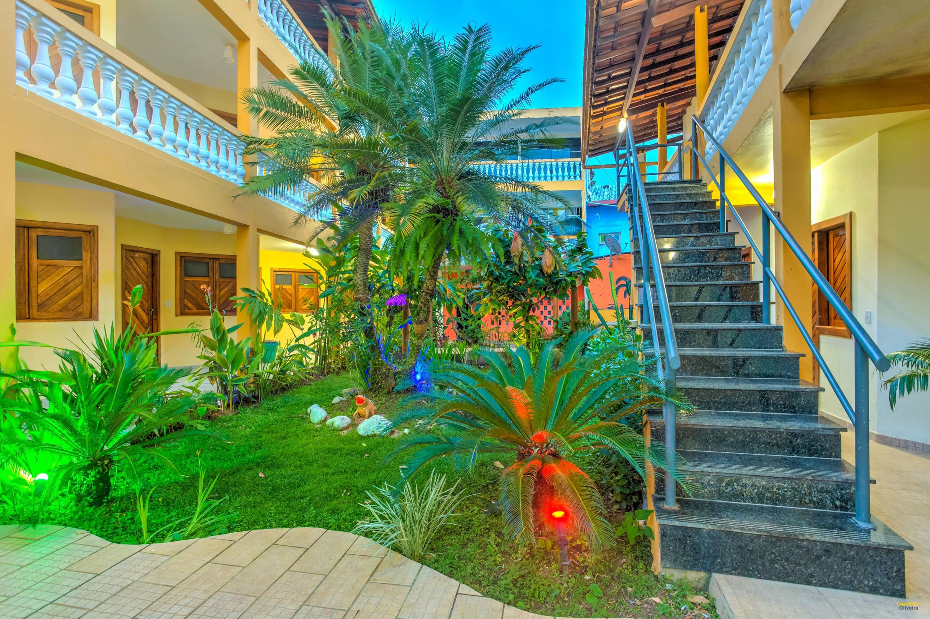 A multi-level building with a staircase, outdoor garden, and multiple doors.