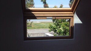 A skylight window with a view of a parking lot and trees. - RENT THE TY BOUCHOT located between St Malo, Cancale and Mont St Michel (Le Vivier-sur-Mer)