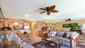 A spacious living area with a sofa, chairs, a coffee table, and a ceiling fan.